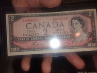Obverse front side of 1954 Canada two dollar banknote showing Queen Elizabeth II portrait, serial number, and bilingual text.