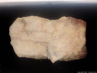 Top view of the quartz specimen showing white crystalline texture with rusty iron oxide stains on irregular surface.