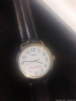 Front view of Timex watch with white face, black numerals, Tim Hortons logo, and black leather band