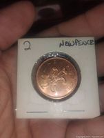 Reverse of coin showing numeral '2' and floral design with inscription 'NEW PENCE'.
