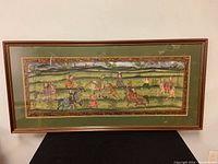 Full view of the framed fabric painting showing a scene with horse riders and tigers.