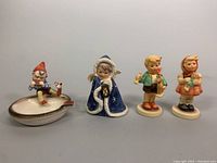 Front view of four Goebel figurines showing detailed features and colors