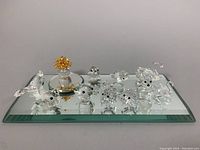 Group photo showing all 12 Swarovski crystal animal and flower figures on a mirror base.