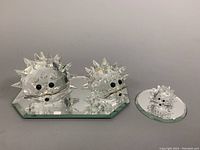 Three Swarovski crystal hedgehog figurines on mirror bases showing relative size and condition