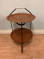 Front three-quarter view of bar cart showing both wooden trays, metal frame and caster wheels