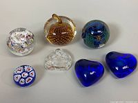 Overview showing all seven paperweights in a single image on white background.