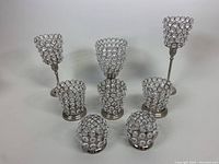 Full lot image showing 8 crystal votive tealight candleholders of assorted heights and widths, placed on white background.