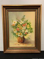 Full shot of the framed oil painting depicting a floral bouquet.