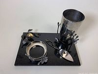 Overall view of granite board with metal vase, spreader and napkin ring