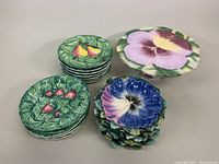 Photo of all plate stacks showing the floral 12-inch cake plate and the fruit themed smaller plates with 3D bas-relief decoration