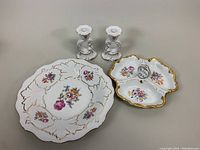 Pair of white porcelain floral decorated Weimar candleholders with gold trim alongside a 3-part divided floral serving dish and a 13" platter with floral and gold accents.