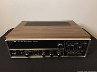 Front and top view of the vintage JVC VR-5521 AM/FM stereo receiver showing wood grain top, metal front panel with control knobs and sliders.