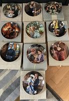 Top view showing all 10 plates placed on top of their striped protective boxes with movie scenes artwork on front.