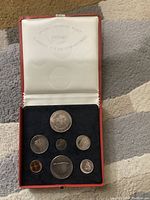 Open red case with six silver Canadian coins and one centennial medal displayed on black velvet insert. Coins and medal show toning.