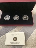 Maroon RCM case open showing three silver coins