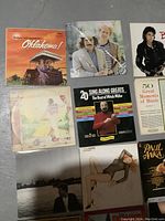 Photo showing vinyl album covers including Oklahoma!, Michael Jackson Bad, and Mitch Miller sing alongs.