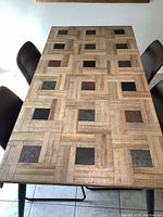 Top view of the wooden kitchen table showing the geometric parquet pattern with square wood inlays