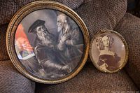 Two framed antique prints posed on fabric surface, showing entirety of both prints and frames.