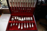 Open chest showing 12 knives in lid and utensils in bottom drawer