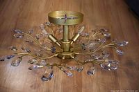 Top angled view showing brass arms with clear crystal accents and 4 adjustable LED light fixtures