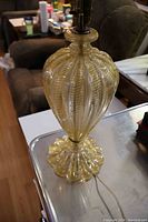 Full view of the Murano glass lamp body showing the yellow gold toned ribbed design with gold dust flakes and the flared molded base.