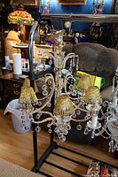Overall view of the Italian gold plated crystal chandelier with six amber glass rod shades and multiple crystal decorations.