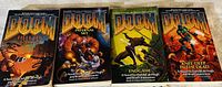 Four Doom novels laid side by side to display covers: Hell on Earth, Infernal Sky, Endgame, Knee Deep in the Dead.
