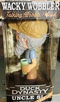 Photo of Uncle Si bobble-head figure in original box, showing side profile and box details