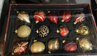 Box of 15 large Christmas tree ornaments in various colors and shapes including red, gold, and black with glitter patterning.