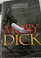 Front cover of the Moby Dick hardcover book by Herman Melville showing title, author, and thematic imagery.