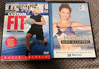 Photo showing two exercise DVDs: 'Custom Fit' by David Snively and 'Precision Body Sculpting' DVD, featuring a woman with resistance bands.
