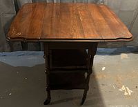 Front view of the wooden teacart showing top surface, legs, and wheels.