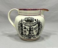 Side view of early 19th century English pearlware Masonic jug with black Masonic transfer print design and pink lustre rim and spout edge. Cream pearlware body with handle.