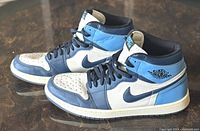 Side view of the Nike Air Jordan 1 Retro High OG Obsidian sneakers showing the Obsidian and white leather panels, black laces, and Air Jordan wings logo.