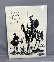 Front view of the black ink canvas art in plastic wrap showing two figures on horseback and windmills in background.
