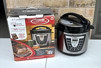Power pressure cooker XL box and cooker side by side showing branding and packaging.