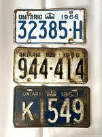 Three vintage Ontario license plates displayed together, showing rust and wear.