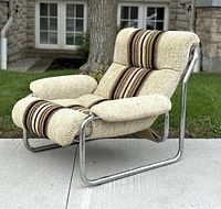 Front left view of lounge chair showing chrome frame and beige striped upholstery