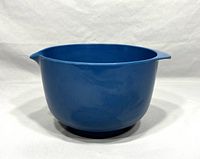Side angle photo showing the blue plastic Rosti mixing bowl with pouring spout and minor surface wear.