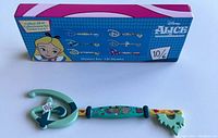 Photo showing the collectible key against its matching themed display box illustrating the series of six keys from Alice In Wonderland, verifying its new condition open box status.