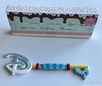 Disney Food Series Donald-themed mystery collector key and its decorative box with candy and chocolate drip motif.