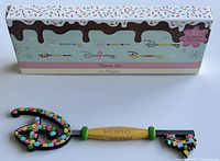 Photo of the Disney Food Series Pluto Collector Key and its original box showing colorful design and Pluto inscription on the key handle.