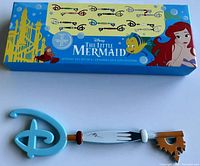 Photo of the open box and the Scuttle-themed collector key from Disney's The Little Mermaid mystery collector key set.