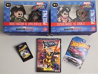 All items in the lot displayed: two Marvel vs Capcom Pixel Pals in original boxes, Spider-Man enamel pin, Marvel DVD, and Hot Wheels car