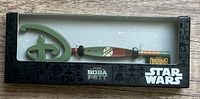 Front view of the collector key in its original black packaging showing the key design with Star Wars and Boba Fett branding.