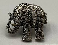 Front view of the silver-tone elephant-shaped ring with rhinestones on the elephant's back and a textured engraved pattern on the body and trunk.
