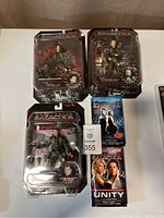 Lot includes 3 Battlestar Galactica action figures in original sealed packaging and 2 Battlestar Galactica novels.