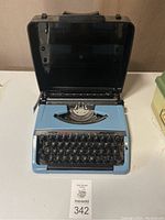 Front view of the Brother Charger 11 manual typewriter inside its black carrying case on a white surface.