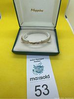 Bangle displayed in original Mappins box on auction signage