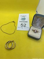 Full jewelry set with 9K gold cameo ring in box, gold-tone chain necklace, and gold-tone hoop earrings on yellow background